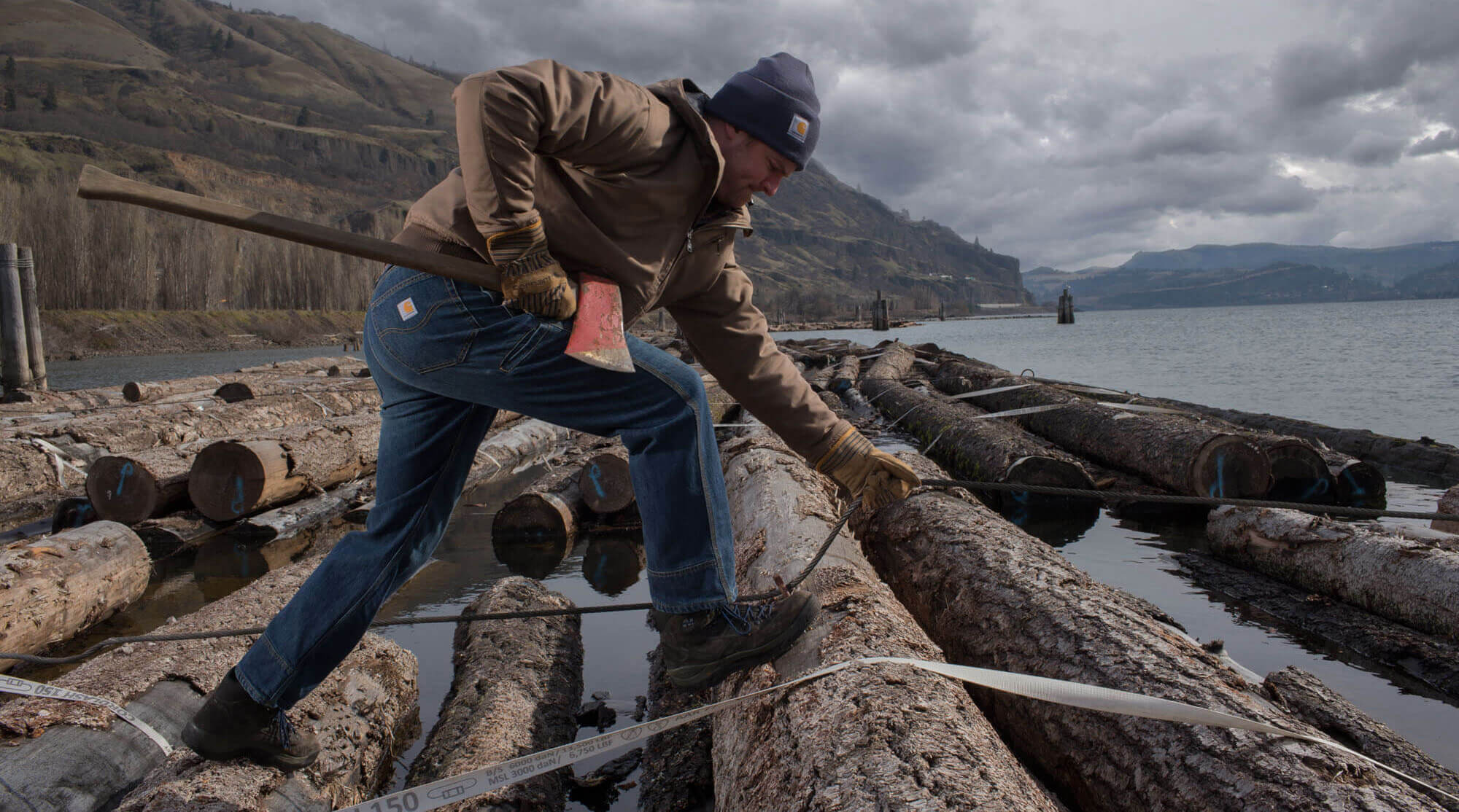 Granite-Carhartt1 Carhartt Clothing showing man carrying an axe logging